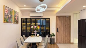 A modern dining area with a large table, chairs, and a decorative light fixture. - Armin Homes Corner 3 BRs with bathtub (Phung Cong)