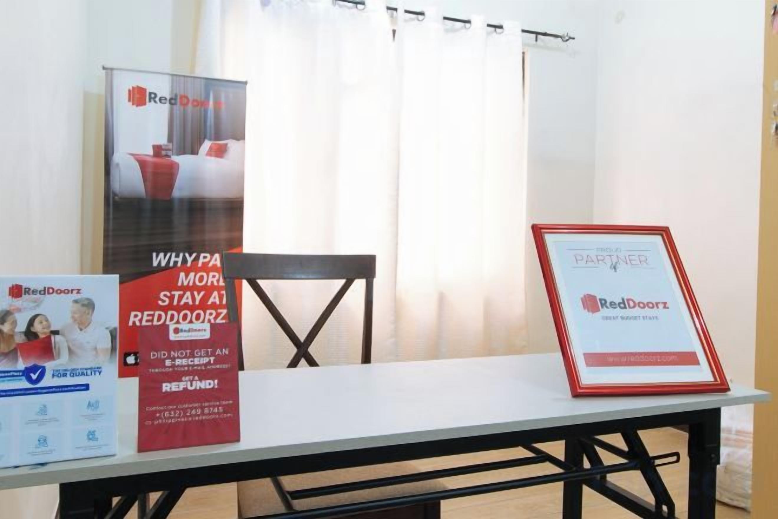 A table with promotional materials for RedDoorz, including a framed certificate and a poster.