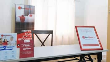 A table with promotional materials for RedDoorz, including a framed certificate and a poster.