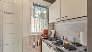 A kitchen with a window, a coffee maker, a toaster, a sink, and a dish soap bottle.