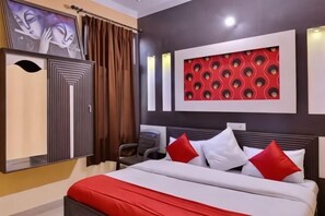 A hotel room with a bed, a wardrobe, a desk, and a wall-mounted TV. - PRINCE RESIDENCY (Amritsar)