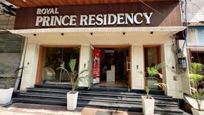 The exterior of the Royal Prince Residency with a wooden facade, large glass entrance, and potted plants at the steps. - PRINCE RESIDENCY (Amritsar)