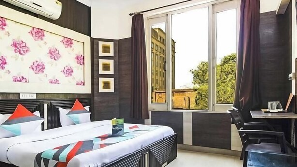A modern hotel room with a large bed, a desk, and a window with a view. - PRINCE RESIDENCY (Amritsar)