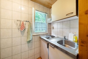 A kitchen with a window, stainless steel sink, and a towel rack.