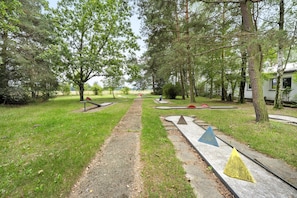 A pathway leading through a park with trees and benches.