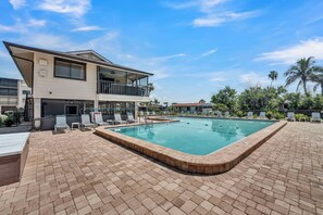 A hotel with a swimming pool, lounge chairs, and a two-story building. - SUMMER SPECIAL DISCOUNT!!!  2B/2B Fairview Isles 214 Condo, Walk to Beach, Heated Pool! (Fort Myers Beach)