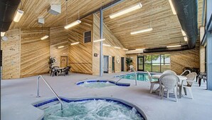 Un área de spa con paredes de madera, varios jacuzzis y zonas de descanso.