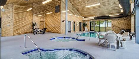 Un área de spa con paredes de madera, varios jacuzzis y zonas de descanso.