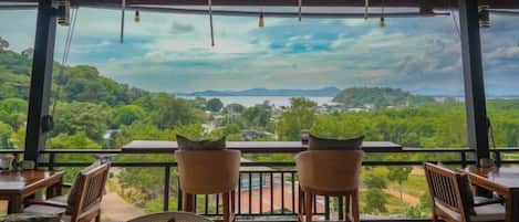 An outdoor seating area with a view of a green landscape.