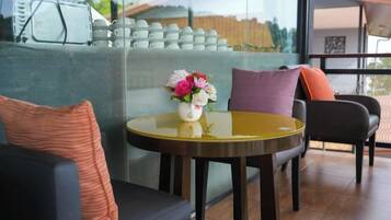 Un intérieur moderne avec une table ronde, un canapé et une cloison en verre.