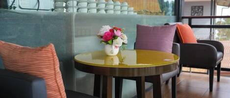 A modern interior with a round table, a sofa, and a glass partition.