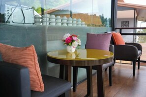 A modern interior with a round table, a sofa, and a glass partition. - So View Phuket Resort (Phuket)