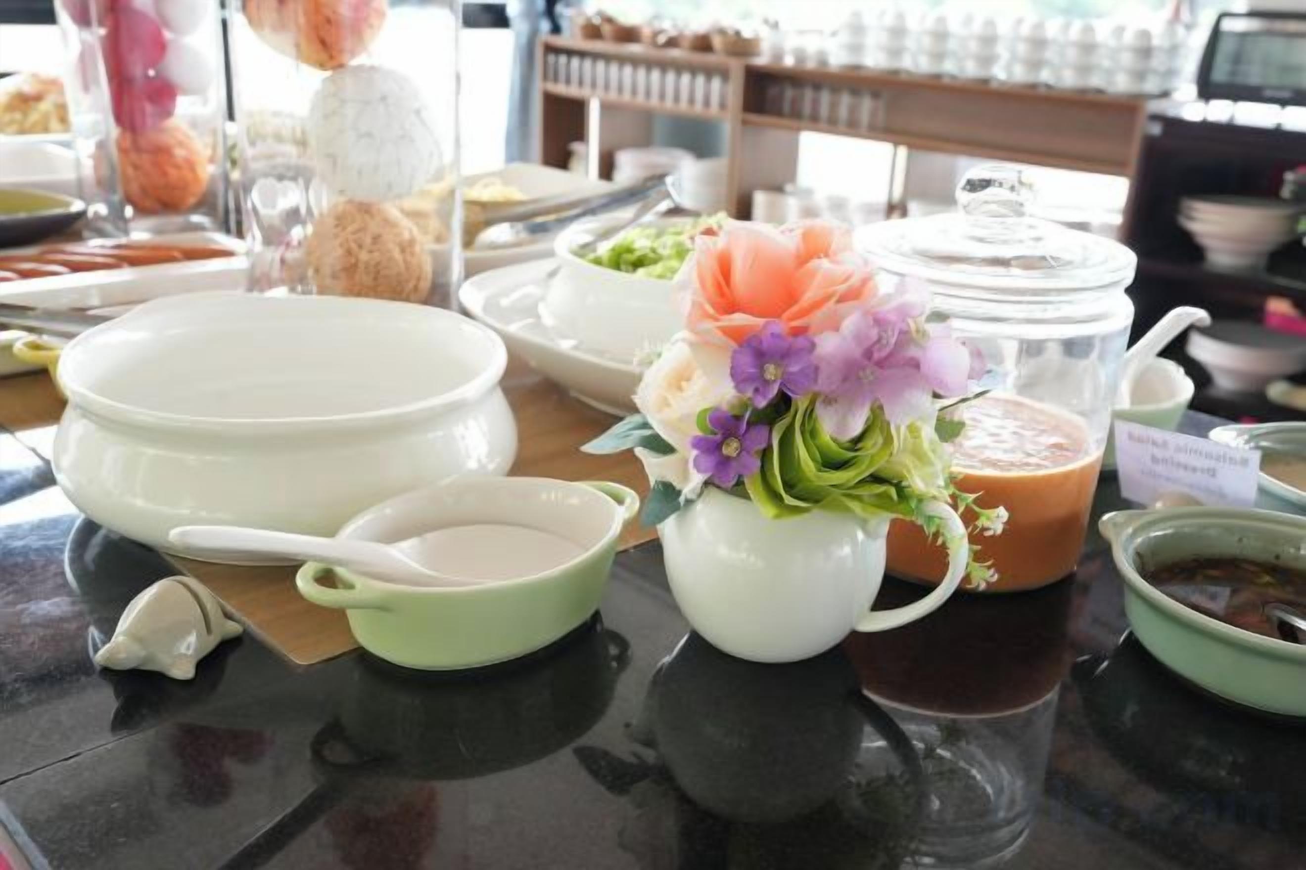 A table with various dishes and a flower arrangement.