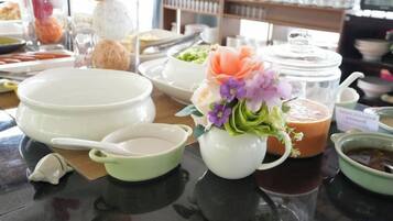 A table with various dishes and a flower arrangement.