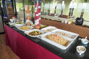 A buffet table with various food dishes and a decorative column. - So View Phuket Resort (Phuket)