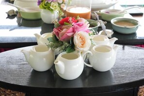A table with teapots and a floral arrangement. - So View Phuket Resort (Phuket)
