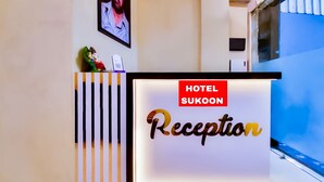 Un comptoir de réception d’hôtel avec une pancarte indiquant « Réception de l’hôtel Sukoon ».