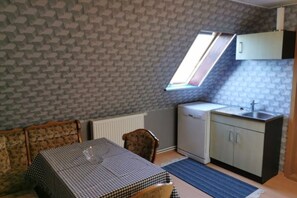 A compact kitchen with a window, a dining table, and a sofa. - Vacation apartment Mary (Karlsburg)