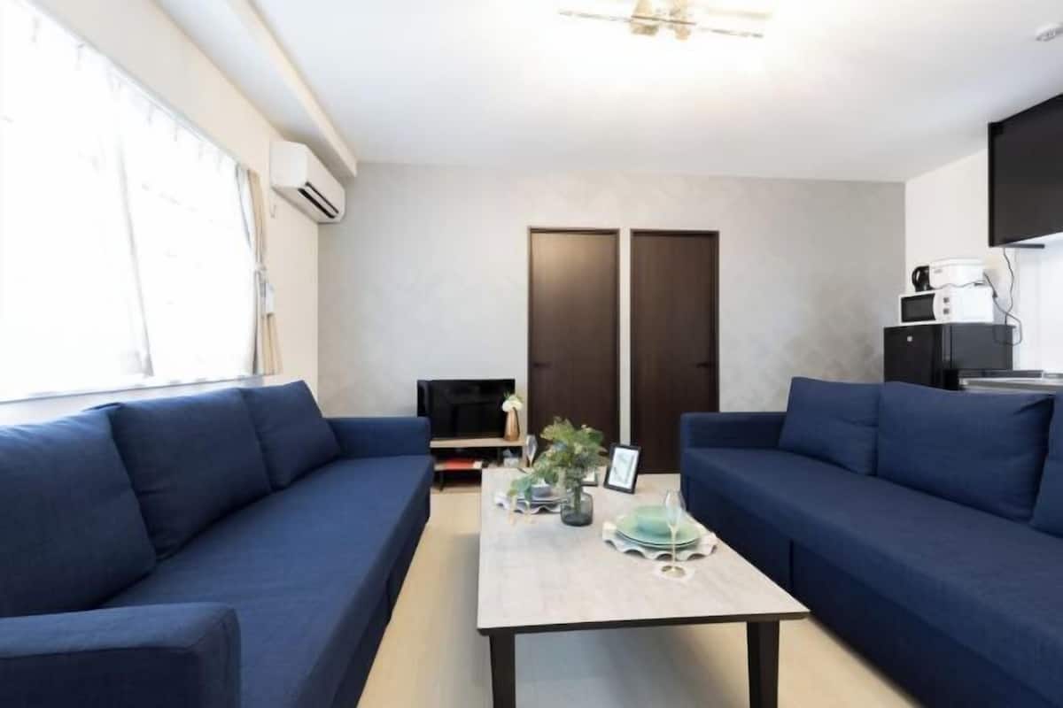Una sala de estar moderna con un sofá, una mesa de centro y un televisor.