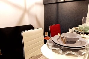 A dining table with a white chair, a red chair, and a glass of wine. - Ra Premier K (Osaka)
