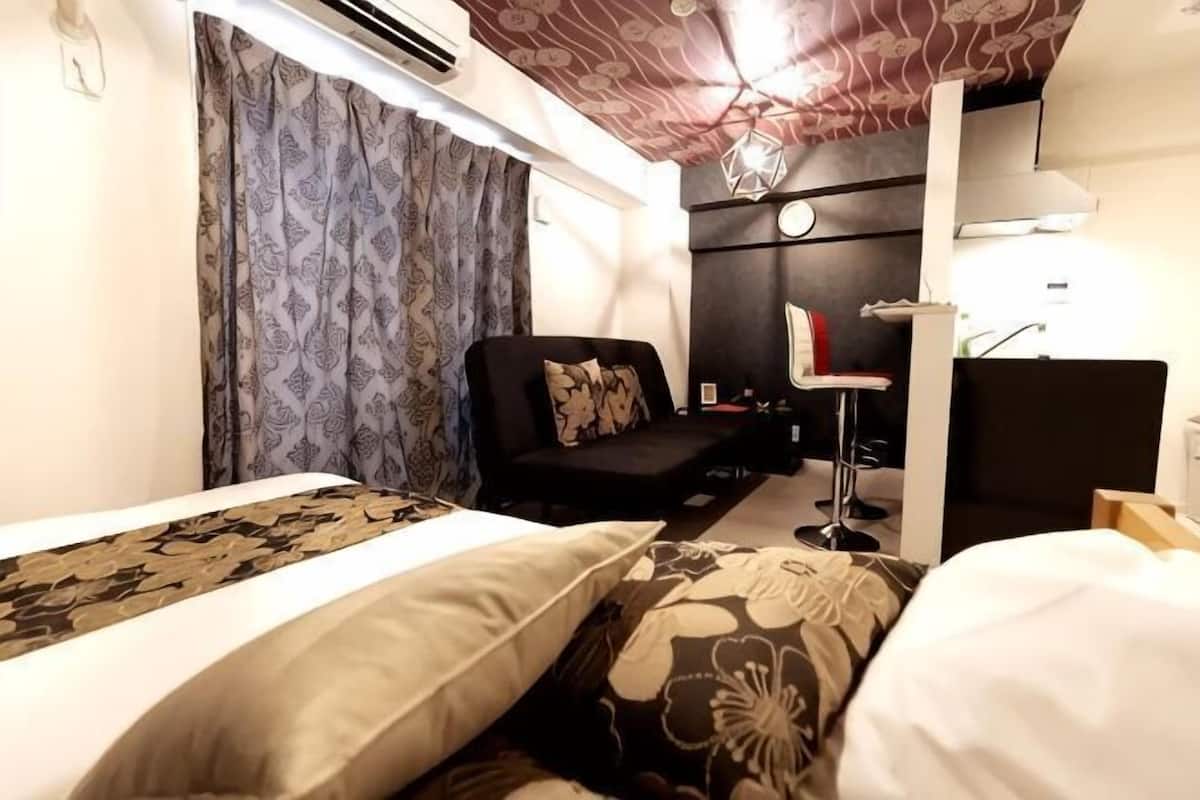 Una habitación de hotel con una cama, un sofá, un escritorio y una silla.