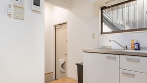 A small, modern bathroom with a toilet, sink, and storage cabinets. - 2/6/MAX4/Nakanoshinbashi (Tokyo)