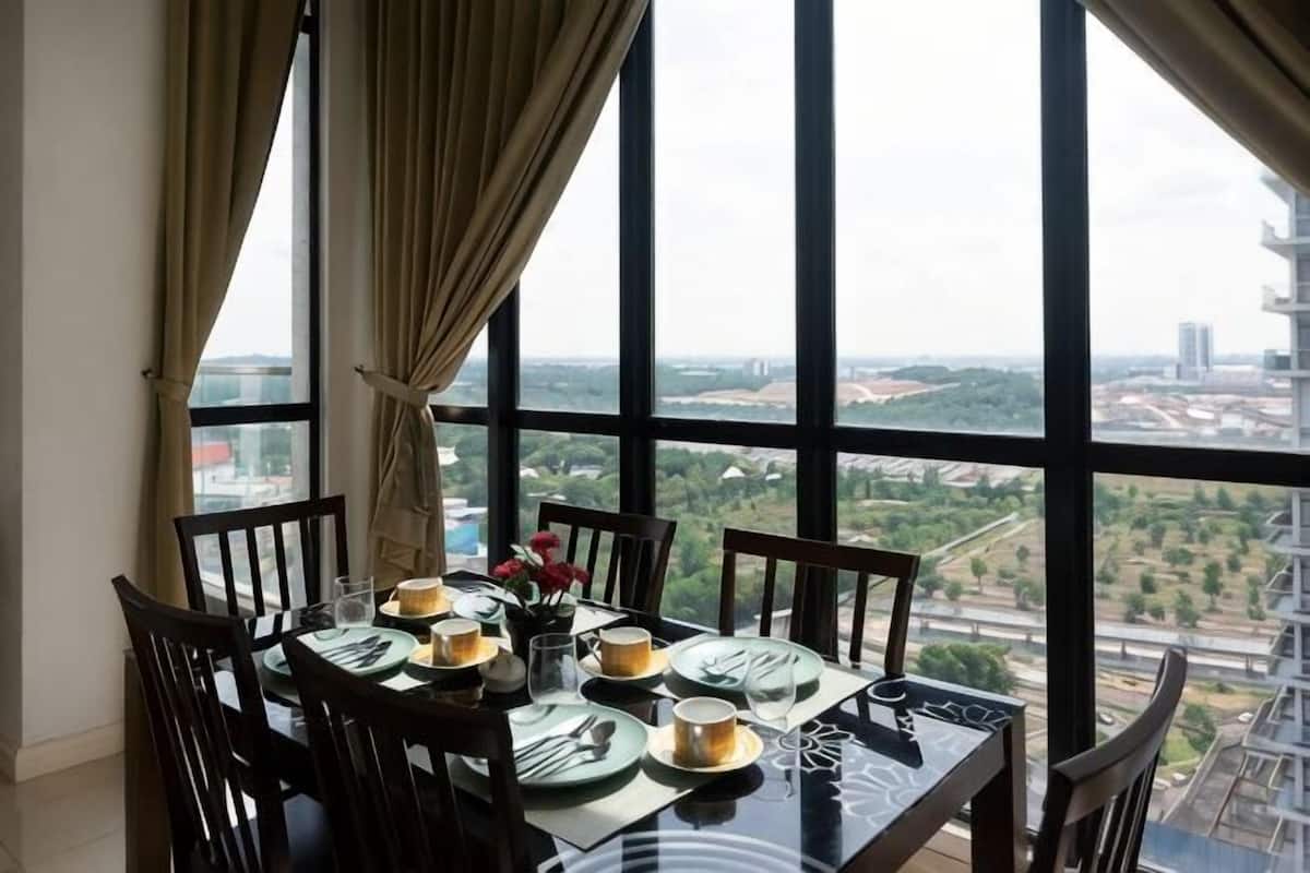 A dining table set for four with a city view through large windows.
