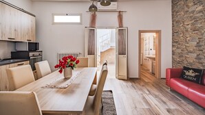 Una cocina moderna con zona de comedor, un sofá de cuero rojo y una pared de piedra.