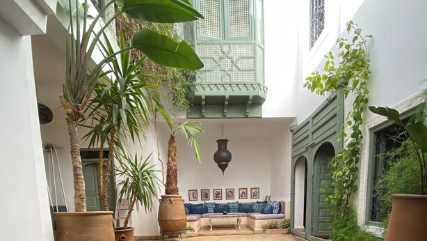 A pool with a tiled edge, surrounded by potted plants and a seating area with cushions. - Luxury and super-stylish riad in the heart of Marrakech Médina, fully staffed (Marrakech)