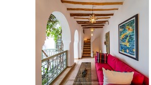 A corridor with a red sofa, wooden beams, and a star-shaped light fixture. - Luxury and super-stylish riad in the heart of Marrakech Médina, fully staffed (Marrakech)