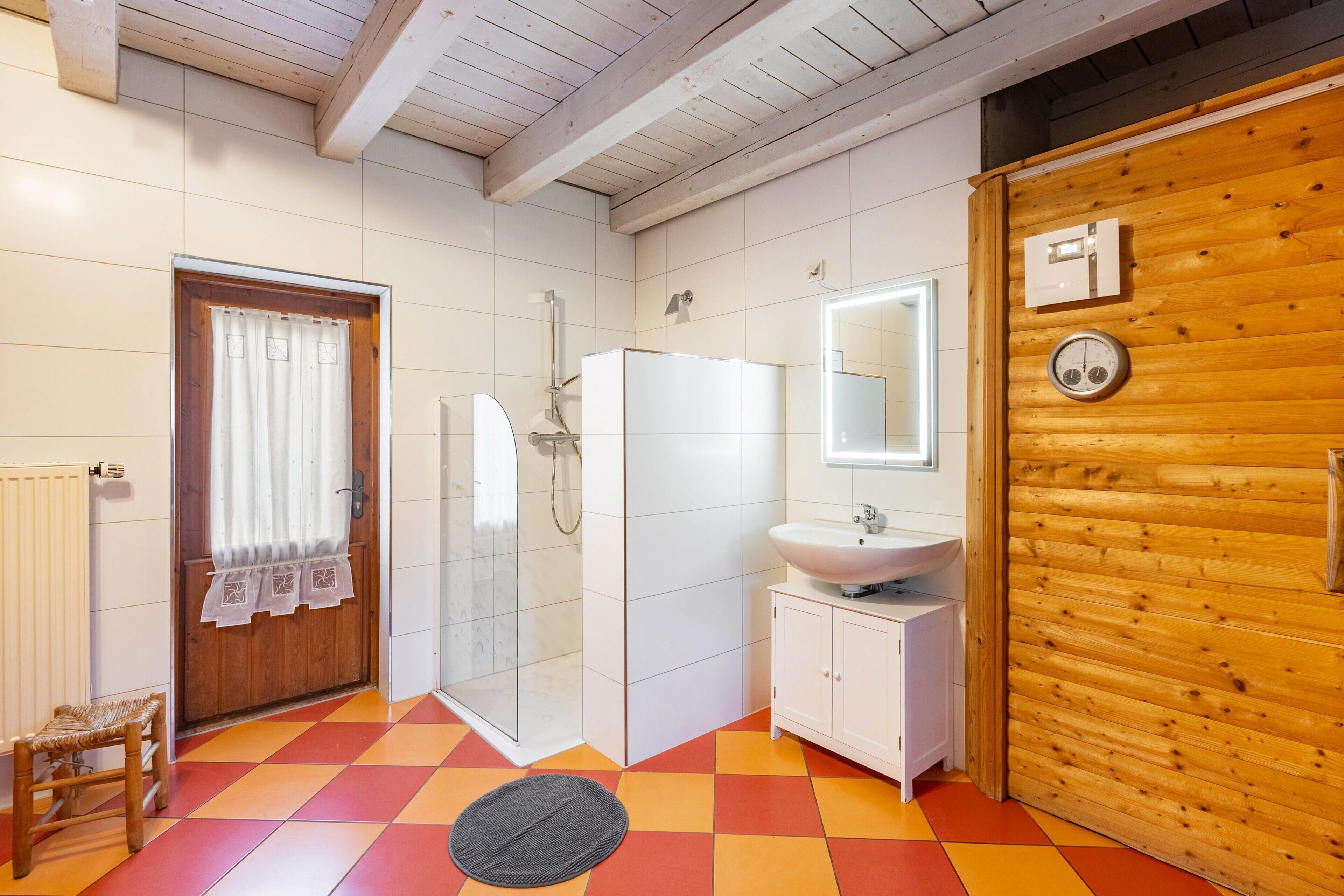 Ein Badezimmer mit Dusche, Waschbecken und Spiegel.