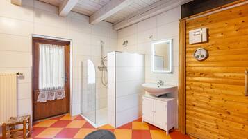 Ein Badezimmer mit Dusche, Waschbecken und Spiegel.