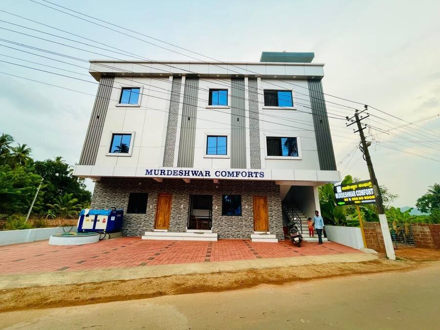 A two-story building with a sign reading 'MURDESHWAR COMFORTS.'