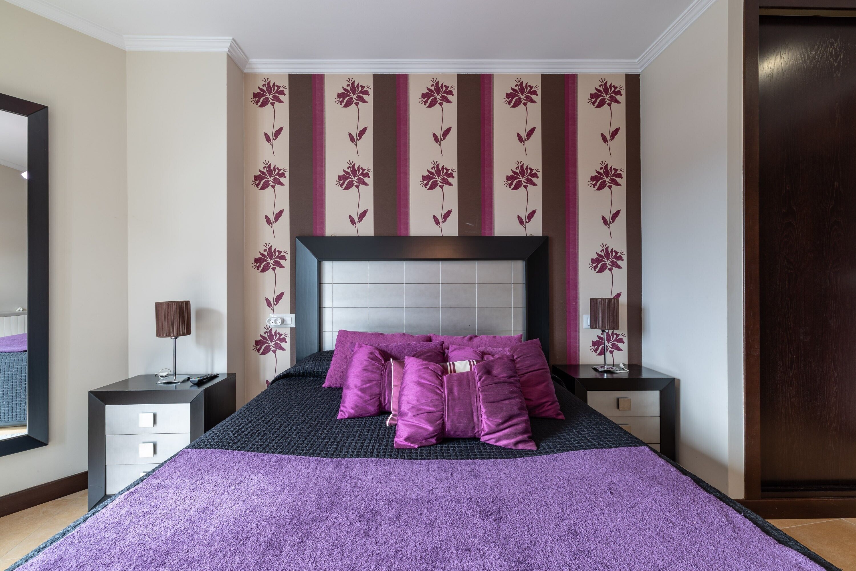 Une chambre à coucher avec un grand lit, une table de chevet avec une lampe et une commode.