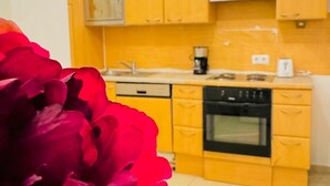 A kitchen with yellow cabinets, a stove, and a coffee maker.