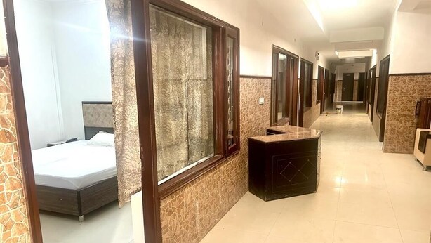 A hotel corridor with a bed, a vanity, and a mirror. - Poonam Villas (New Delhi)