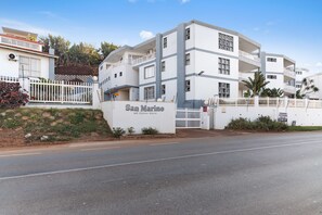 A multi-story building with a white facade and balconies, named "San Marino" at 60 Ocean Drive. - San Marino 17 (Ballito)