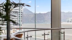 Ein modernes Hotelzimmer mit Balkon mit Blick auf Berg und Strand.