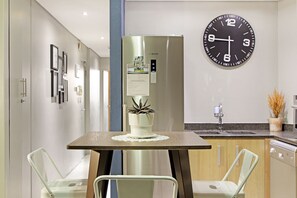 A modern kitchen with a Bosch refrigerator, a wall clock, and a sink.