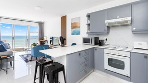Una cocina moderna con armarios grises, encimera blanca y horno empotrado.