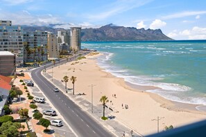 A coastal road with a beach and buildings.