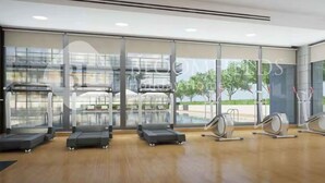 A modern gym with treadmills, elliptical machines, and a rowing machine. - 108-Bloomfileds Cozy STU in Park View  (Abu Dhabi)