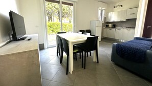 Un espacio habitable moderno con comedor, kitchenette y sofá.