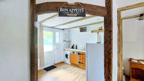 A kitchen with wooden cabinets, a washing machine, and a sign that reads "Bon Appetit". - Stunning home in Zutkerque with WiFi (Zutkerque)