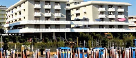 A multi-story hotel with balconies and air conditioning units.
