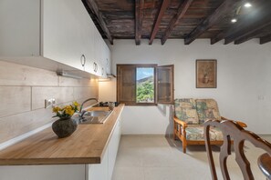 A kitchen with wooden cabinets, a sink, and a window with a view.