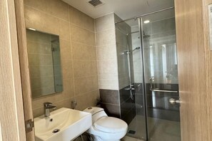 Ein modernes Badezimmer mit Waschbecken, Toilette und einer Duschkabine aus Glas.