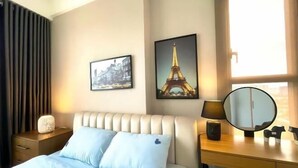 A hotel room with a bed, a nightstand, a dresser, a mirror, and two framed pictures on the wall. - Solina Home Sun Anvenue Apartment (Ho Chi Minh City)