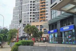 A modern urban setting with high-rise buildings, a pharmacy, and a gated entrance. - Solina Home Sun Anvenue Apartment (Ho Chi Minh City)