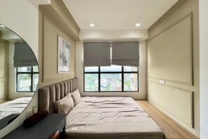 Une chambre à coucher avec un grand lit, une table de chevet, un miroir et une fenêtre donnant sur un beau paysage.
